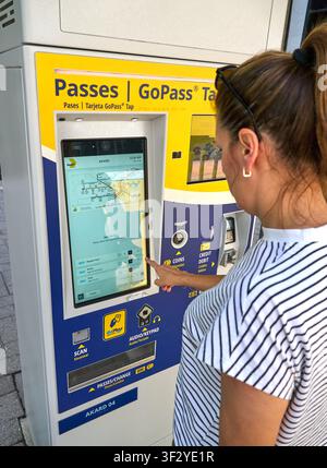 DALLAS, TX, ÉTATS-UNIS - 11 JUIN 2026 : Une femme interagit avec un distributeur de billets DART GoPass à la station Akard de Dallas, sélectionnant des options sur l'écran tactile Banque D'Images