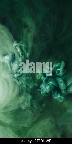Éclaboussure de fumée. Jet d'encre. Explosion de pulvérisation de pigment vert dans un liquide aquarelle noir. Mélange de brume scintillante artistique, fond flou abstrait. Banque D'Images