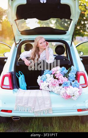 Voyageur magnifique reposant dans un hayon ouvert entouré d'hortensias et d'une douce lumière dorée dans un paysage rural paisible Banque D'Images