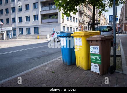 Katowice, Pologne - 04 mai 2024 : Trois bennes à ordures pour les déchets biologiques, le recyclage du plastique et du papier dans la rue Saint-André par une journée de printemps ensoleillée. Banque D'Images