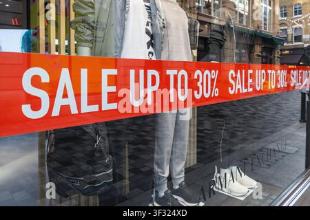 Une bannière de vente rouge vif offrant jusqu'à 30 % de rabais sur une vitrine de magasin de détail. Londres, Royaume-Uni, 23 juillet 2023 Banque D'Images