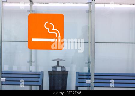 Abri de fumeurs en verre moderne avec panneau indiquant la zone fumeurs désignée Banque D'Images