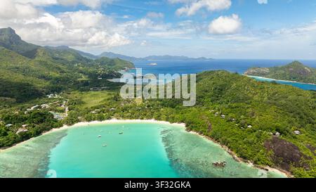 Vue aérienne de la baie aux eaux azur calmes et au paysage montagneux dramatique. Plage de Port Launay. Seychelles. Banque D'Images