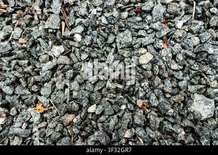 Gros plan en vue par le dessus de gravier gris broyé avec des formes angulaires variées, créant une texture d’agrégat de construction rugueuse Banque D'Images