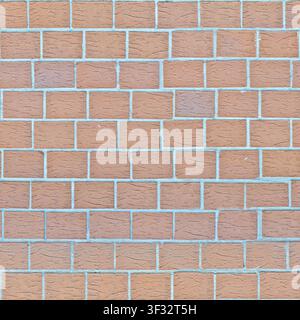 Une texture sans joint d'un mur de briques rouges avec du mortier gris. Banque D'Images
