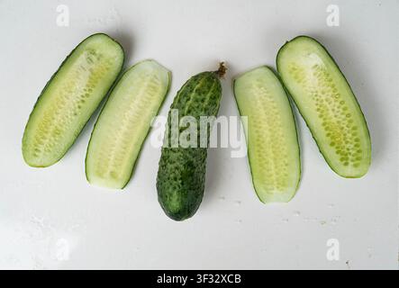 Concombre frais entier et tranché isolé sur fond blanc Banque D'Images