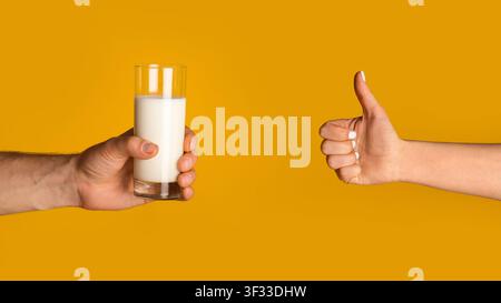 Mains de jeunes hommes tenant un verre de lait et de femmes montrant des pouces vers le haut geste sur fond orange, espace vide Banque D'Images