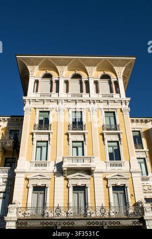 Façade historique de bâtiment de luxe à Lugano, Suisse. Vue verticale à faible angle d'une structure architecturale européenne classique présentant un mur jaune Banque D'Images