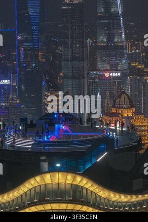 Vue aérienne du pont d'observation illuminé du Shanghai Baiyulan Plaza avec des gens profitant de la skyline nocturne de Shanghai, Shanghai, Chine. Banque D'Images