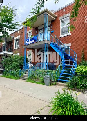 Bâtiments résidentiels traditionnels en briques rouges avec escaliers extérieurs et balcons dans une rue arborée à Villeray, Montréal, Québec, Canada. Banque D'Images