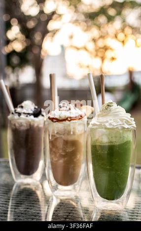 Boissons milkshake sundae glacé au chocolat, au café et au matcha sur une table de café en plein air en été Banque D'Images