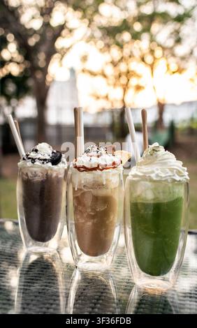 Boissons milkshake sundae glacé au chocolat, au café et au matcha sur une table de café en plein air en été Banque D'Images
