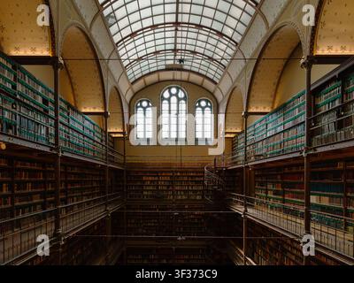 Photographie éditoriale de la bibliothèque de recherche emblématique du Rijksmuseum présentant des galeries de livres historiques, des étagères en fer forgé et une architecture de toit en verre Banque D'Images