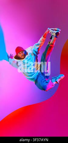 Jeune breakdancer dynamique en plein vol à travers un design vertical coloré pour poster Banque D'Images