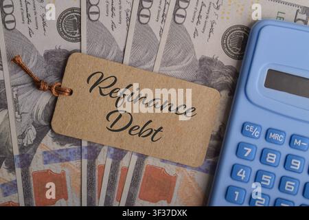 Concept de refinancement de dettes avec calculatrice, étiquette financière et billets en dollars représentant la restructuration de prêts, la gestion des dettes, les finances personnelles et la banque Banque D'Images