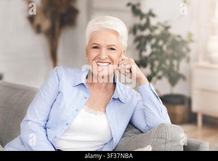 Portrait d'une charmante femme âgée avec un beau sourire posant dans l'intérieur d'une maison Banque D'Images
