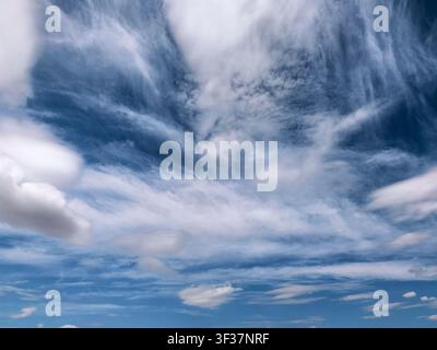 De belles couches de nuages cirrus et cumulus contre un ciel bleu vif. Fond atmosphérique naturel avec des formations nuageuses dramatiques et une texture douce Banque D'Images