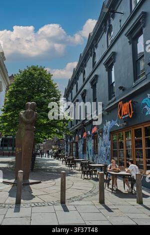 Un jour ensoleillé dans la rue Bold de Liverpool, des amis se rassemblent à des tables en plein air, profitant d’un bon repas et de conversations animées à l’ombre d’un arbre. Banque D'Images