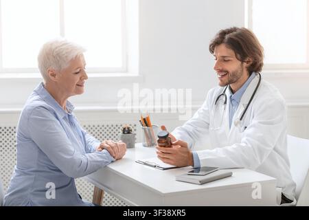 Médecin professionnel indiquant le calendrier des pilules à un patient âgé Banque D'Images