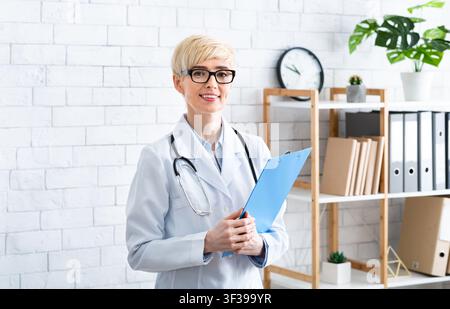 Professionnel médical. Médecin avec une tablette à la main à l'intérieur du bureau Banque D'Images