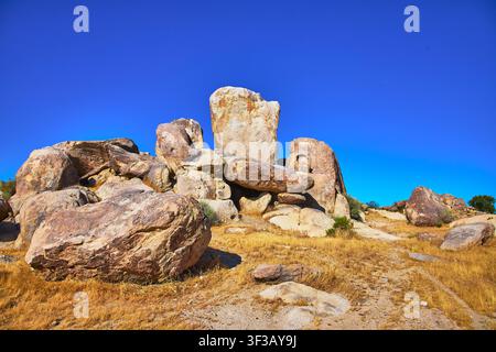 Formations rocheuses massives et paysage désertique sous un ciel bleu éclatant Banque D'Images