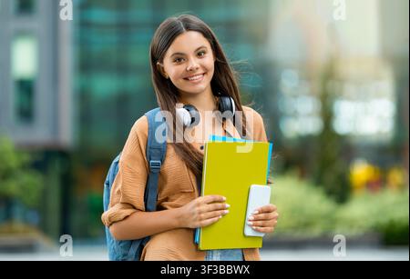 Joyeuse belle femme étudiante posant sur le campus universitaire, espace de copie Banque D'Images