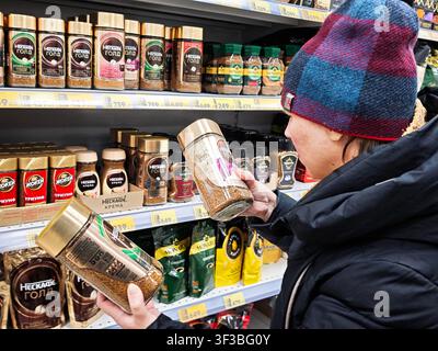Kirov, Russie – 01 février 2026 : Un client examine différentes bocettes de café en faisant ses courses dans un supermarché un week-end. Les étagères sont remplies de Var Banque D'Images