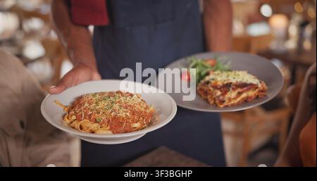 Mains, serveur et nourriture au restaurant avec un couple, repas gastronomique et cuisine fine pour un anniversaire. Employé, service et personnes avec assiette pour italien Banque D'Images