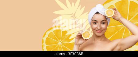 Jeune femme tenant des tranches de citron avec une serviette sur la tête, souriante, concept de soins de la peau Banque D'Images