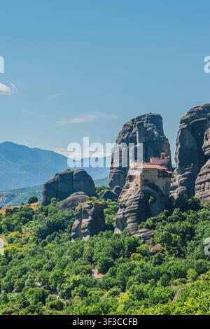 Vue verticale du complexe monastique de Rousanou construit sur une falaise verticale entourée de hautes formations rocheuses et d'un paysage forestier verdoyant à Météora en Thessalie Banque D'Images