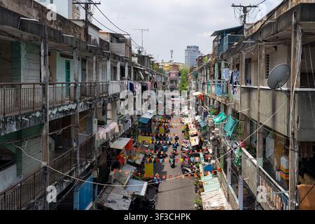 Vue aérienne d'un ancien complexe d'appartements et d'un marché de rue animé le long de Nguyen Thien Thuat à Ho Chi Minh Ville, montrant une vie urbaine dense et des bâtiments usés Banque D'Images