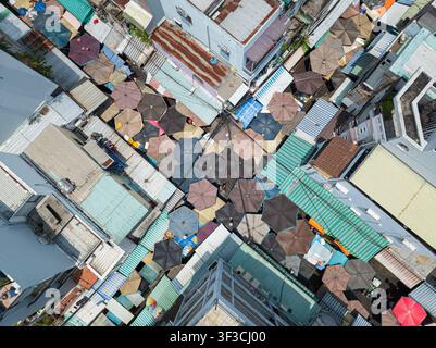 Vue aérienne par drone d'un complexe résidentiel ancien et dense dans la rue Nguyen Thien Thuat à Saïgon, avec des toits colorés, des auvents, des balcons et usés Banque D'Images