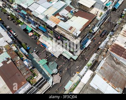 Vue aérienne d'un ancien complexe d'appartements et d'un quartier densément peuplé le long de la rue Nguyen Thien Thuat à Saigon, Vietnam, entouré de toits, de boutiques, alle Banque D'Images