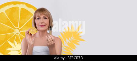 Femme tenant un citron et une bouteille d'huile essentielle, concept de soins de la peau frais Banque D'Images