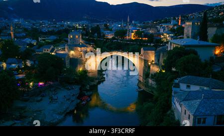 Mostar, Bosnie-Herzégovine – 7 juin 2026 : Vue aérienne nocturne du Vieux Pont illuminé enjambant la rivière Neretva Banque D'Images
