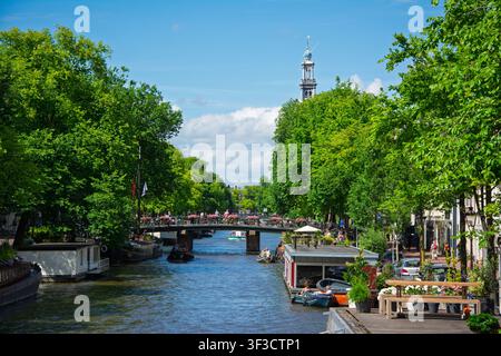Amsterdam, Pays-Bas. 22 juin 2014, canal d'Amsterdam avec circulation de bateaux et tour de la Westerkerk Banque D'Images