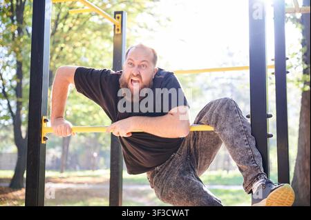 Homme étonné en vol. Homme en plein vol au-dessus d'un bar exprimant un choc ludique avec énergie. Individu surpris en vol au-dessus d'un bar arborant une expression vive dans un parc capturée de manière dynamique Banque D'Images