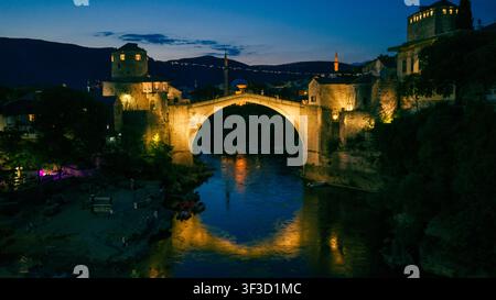 Mostar, Bosnie-Herzégovine - 7 juin 2026 : Vue aérienne rapprochée nocturne du Vieux Pont illuminé au-dessus de la rivière Neretva Banque D'Images