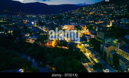 Mostar, Bosnie-Herzégovine – 7 juin 2026 : Large panorama aérien nocturne du centre-ville historique illuminé Banque D'Images