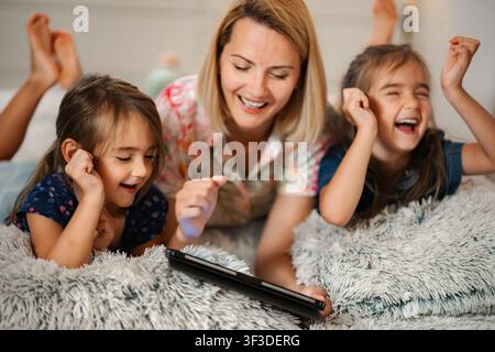 Famille regardant une tablette numérique, s'amusant et souriant ensemble Banque D'Images