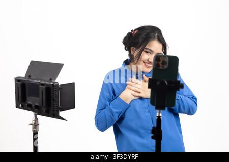 Créatrice de vidéos féminine enregistrant du contenu de vlog à l'aide d'une configuration de caméra en studio Banque D'Images
