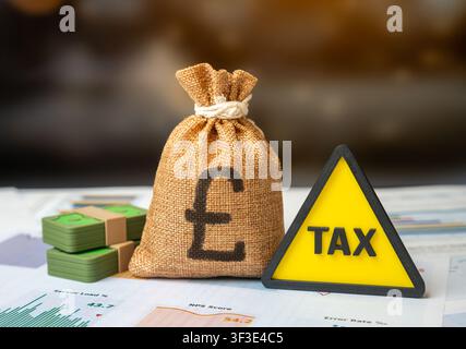 Symbole d'attention aux taxes et sac d'argent en livres britanniques. Déclarations financières. Période de paiement des taxes. Banque D'Images