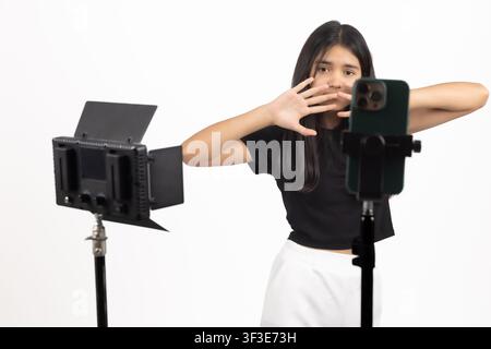 Créatrice de contenu féminine gesticulant avec les mains en enregistrant un vlog sur téléphone Banque D'Images