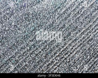 Un gros plan détaillé montre une surface très texturée composée de nombreux petits fragments gris irréguliers et scintillants avec des touches de couleurs subtiles Banque D'Images