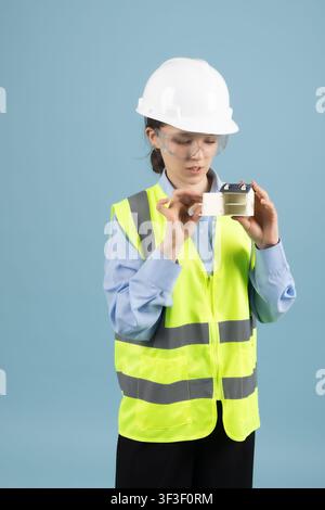 Ouvrier du bâtiment confiant portant un casque de sécurité et un gilet Banque D'Images