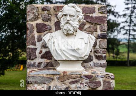 Le buste en marbre de Henry Wadsworth Longfellow se dresse sur Miner Lane au Grand-Pré National Historic Site en Nouvelle-Écosse, Canada. L'historien local John Frederic Herbin a commandé au sculpteur Sir Thomas Brock de le créer en mémoire du poème épique de Longfellow ‚Evangeline‘, qui raconte l'histoire de l'expulsion des Acadiens Banque D'Images