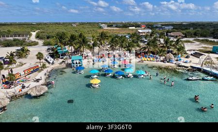 Vue aérienne de Secret Beach avec des parasols colorés, une eau turquoise, des palmiers et des gens qui nagent à San Pedro, dans le district de Corozal, au Belize. Banque D'Images