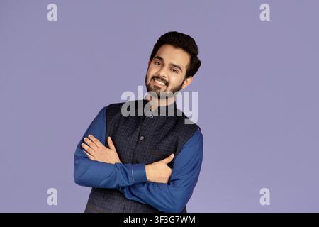 Portrait d'un homme indien positif avec bras croisés sur violet arrière-plan Banque D'Images