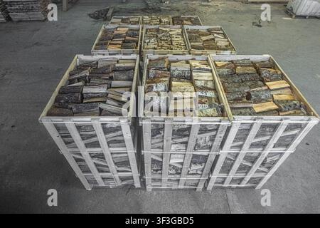 Vue de bois de chauffage empilé dans des caisses en bois dans un entrepôt en Lettonie. Banque D'Images