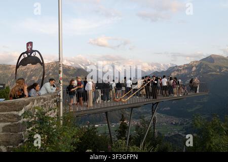 Les touristes profitent de vues panoramiques depuis le Harder Kulm dans les Alpes bernoises, Suisse. Des musiciens d'alphorn jouent sur la plateforme, avec Interlaken et la montagne Banque D'Images